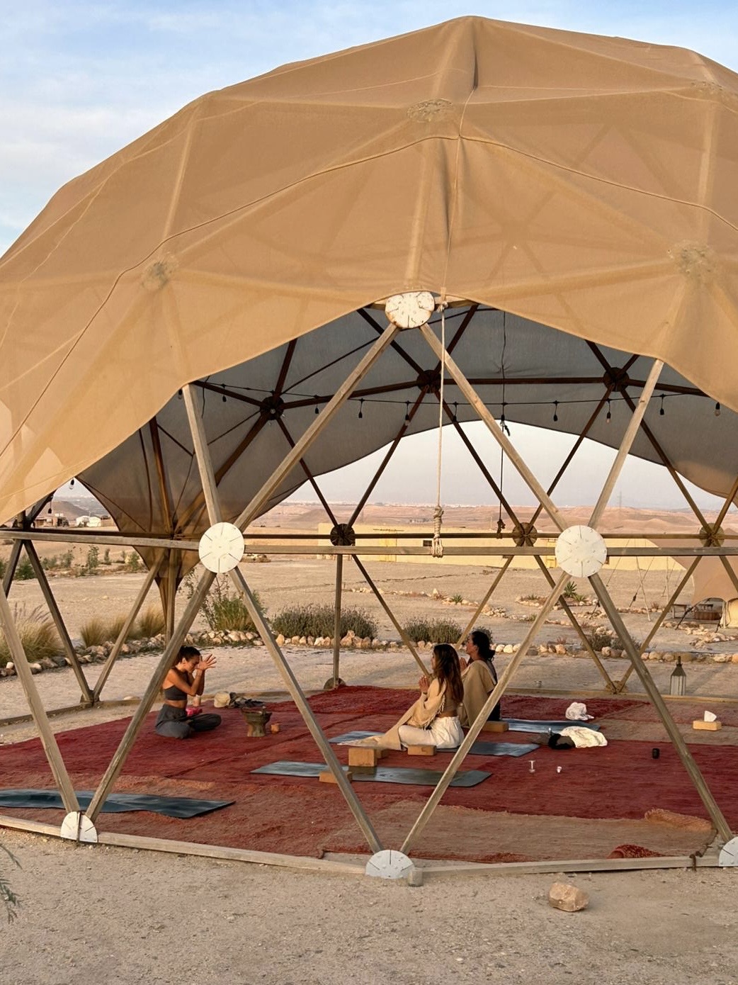 Sophie Amelia leading a yoga session in a desert retreat dome